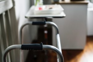 A zimmer frame with table in the background with various items on it